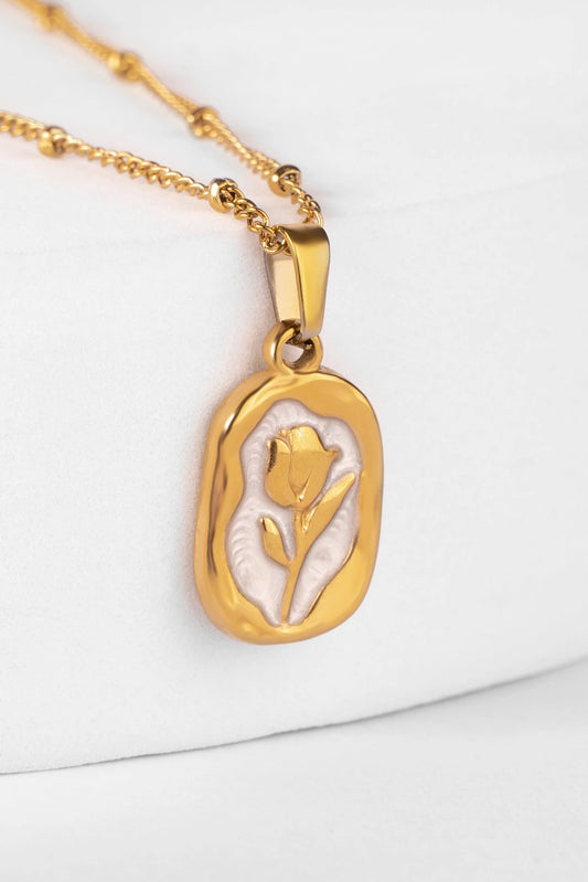 Gold necklace with a pendant featuring a tulip design on a white background