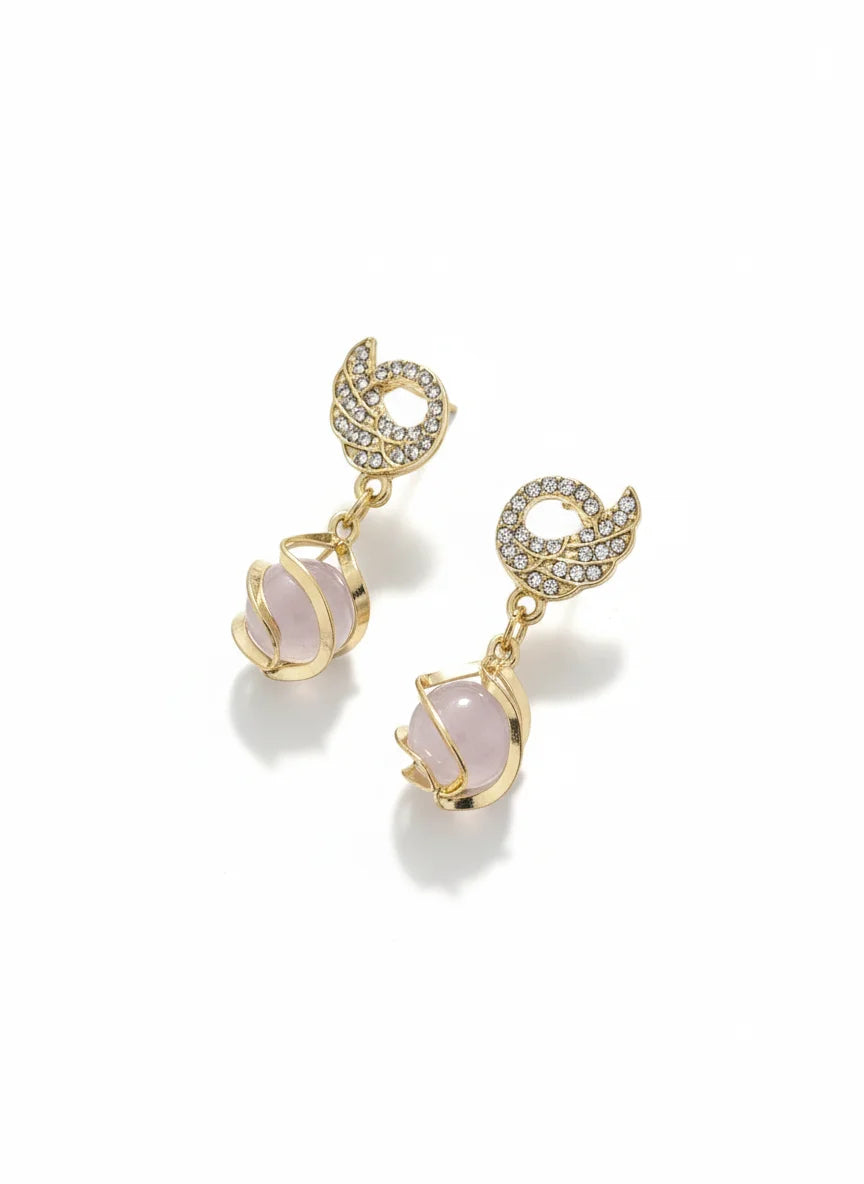 Gold earrings with pink gemstones on a white background