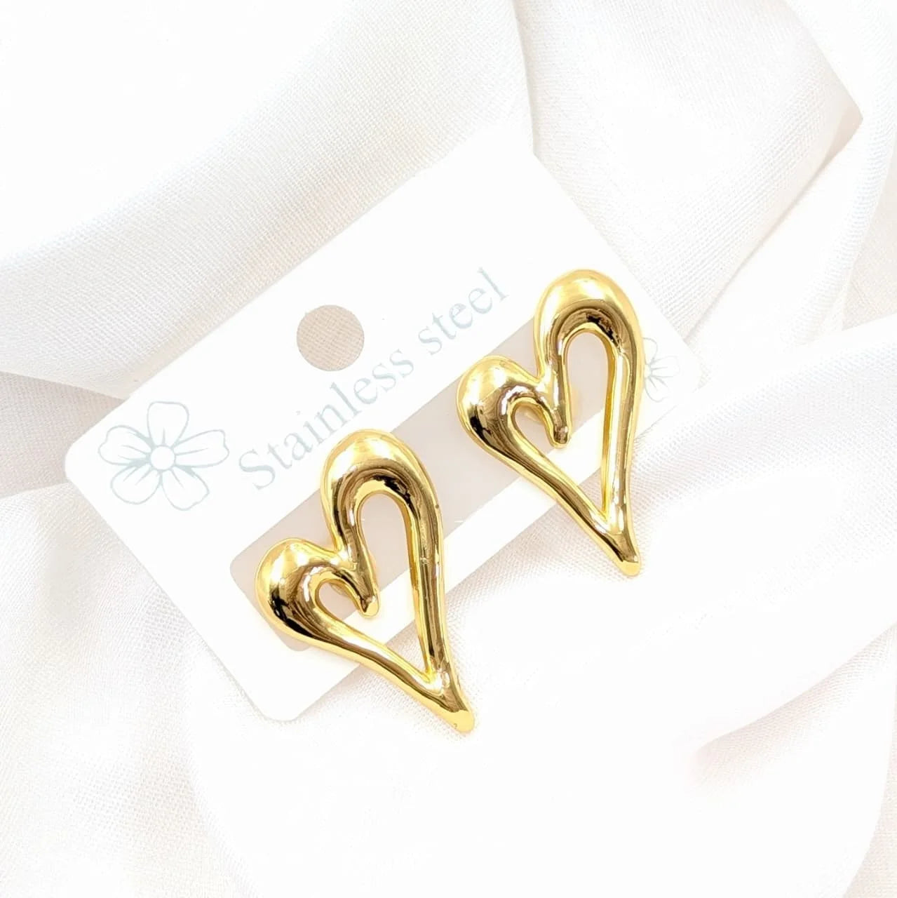 Gold heart-shaped earrings on a white card with 'Stainless Steel' text.